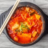Jjigae · A tofu stew with vegetables cooked in a spicy fish broth topped with an egg. Served with ste...