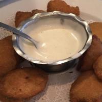 Deep-Fried Zucchini · A large plate of battered zucchini slices with a side of our buffermilk ranch dressing.