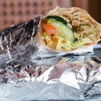 Falafel Sandwich · Tahini sauce, falafel, hummus, pickles and french fries inside. Lightly toasted white pita b...