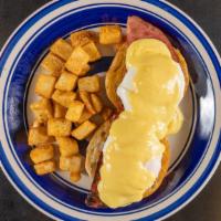 Eggs Benedict · Two poached eggs served over English muffin with ham and topped with hollandaise sauce serve...