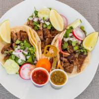 Steak Tacos · Three tacos served with corn tortilla, onions cilantro and hot sauce on the side.