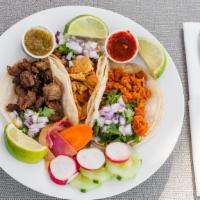 Carnitas Tacos · Three tacos served with corn tortilla, onions cilantro and hot sauce on the side.