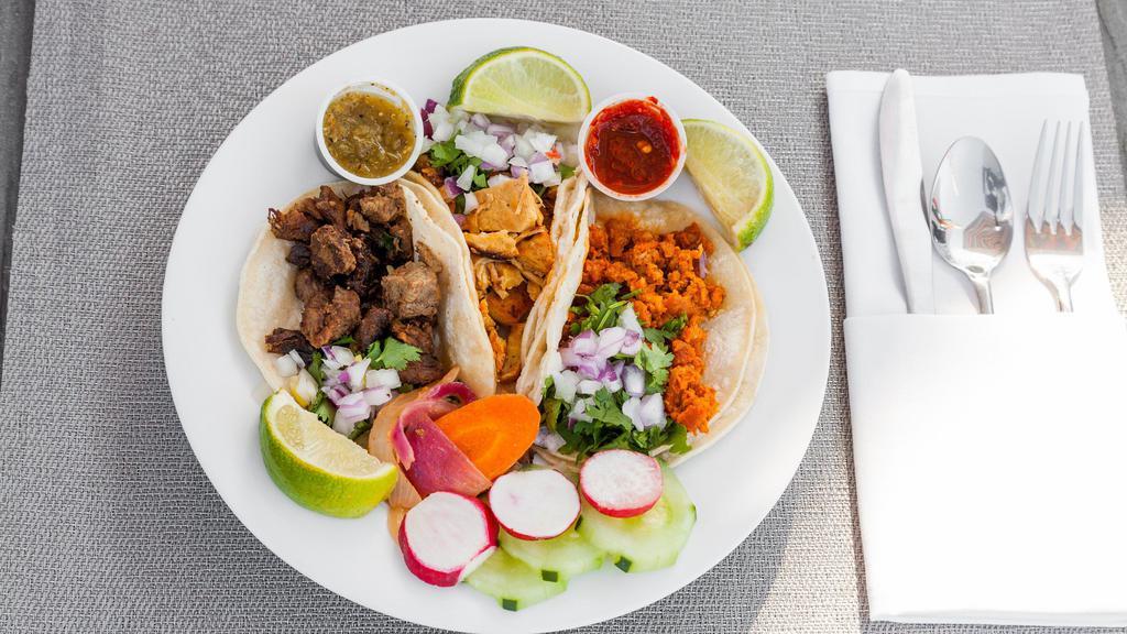 Carnitas Tacos · Three tacos served with corn tortilla, onions cilantro and hot sauce on the side.