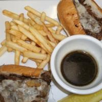 French Dip Sandwich · Shaved prime rib topped with fired onions and Swiss cheese. Served with french fries and a s...