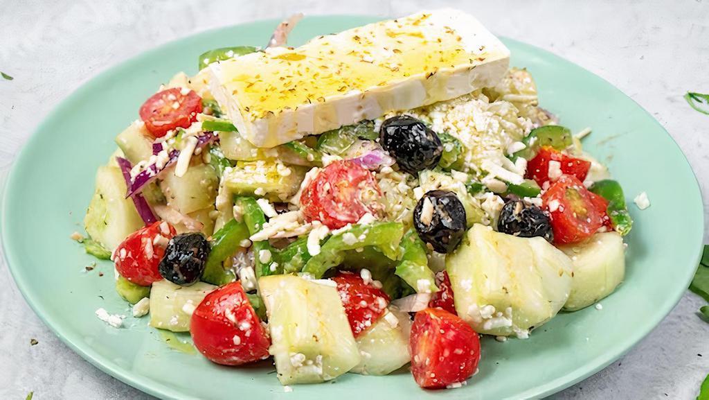 Horiatiki (Village Salad) · Tomatoes, cucumbers, red onions, green peppers, feta cheese, olives, and extra virgin olive oil.