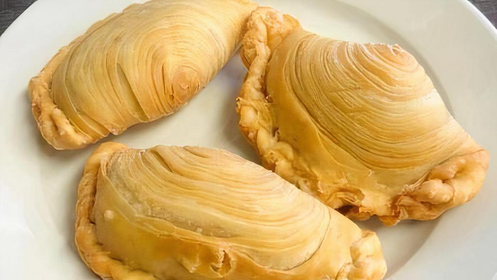 Curry Puff (Chicken Curry) · Handmade Thai pastry is flavorful, filled with chicken and curry.