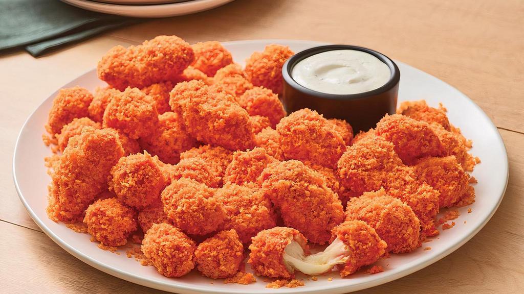 Cheetos® Cheese Bites · Crispy Cheese Bites tossed in sauce and coated in crunchy original Cheetos® crumbles. Served with house-made buttermilk ranch or Bleu cheese dressing for dipping.