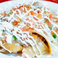 Nachos Grande · Home-made crispy corn tortilla chips pilled with beans and melted cheese, topped with sour c...