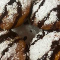 Fried Oreos · Four pieces with powdered sugar and drizzled chocolate syrup