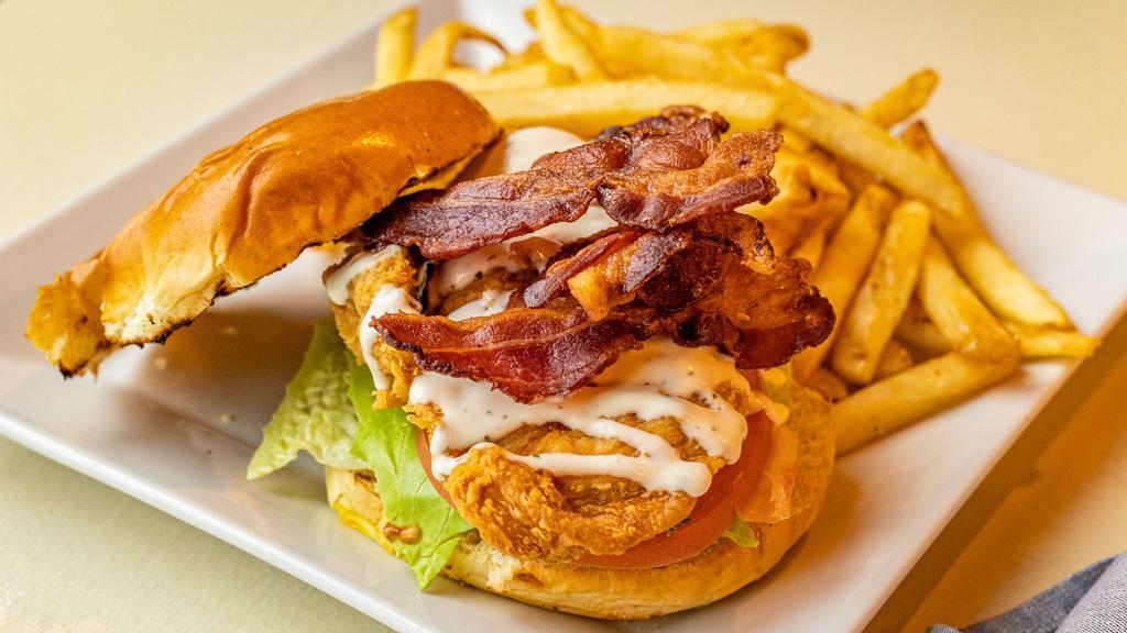 Bacon Ranch Crispy Chicken Sandwich · Marinated chicken, doused in flour and fried to a golden crisp. Topped with ranch dressing, Applewood smoked bacon, lettuce and a freshly sliced tomato. Served atop a brioche bun.