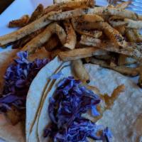 New England Fish Tacos · Battered and fried haddock, house slaw, drizzled with Caribbean tartar sauce. Served atop a ...