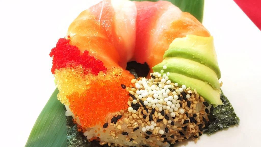 Sushi Donut · Pressed sushi rice with spicy tuna inside, topped with tuna, salmon, avocado, sesame seeds and tobiko, side of eel sauce and spicy mayo