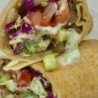 Braised Beef Pita · Braised beef, served with hummus, fresh parsley, cucumber, pickles and tahini sauce inside a...