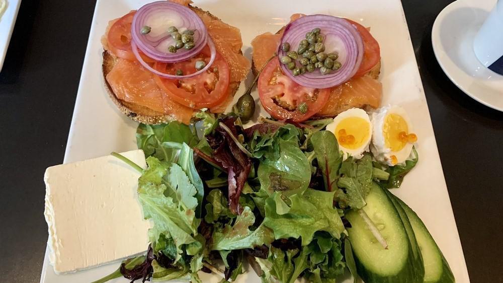 Norwegian Smoked Salmon & Bagel · With caper berries, tomatoes, boiled egg, salmon caviar, English cucumber, sliced red onion, cream cheese, and mixed greens.