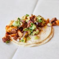 Specialty Al Pastor · Marinated pork cooked on a rotisserie with pineapple and onion.  Served with Cilantro, Red O...