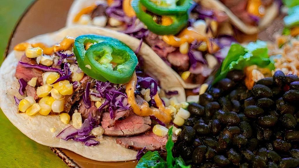 Grilled Street Corn & Steak Tacos · A summery version of our classic steak taco with grilled flank steak, grilled corn, chipotle aioli, Cotija cheese, red cabbage, cilantro and jalapeño.