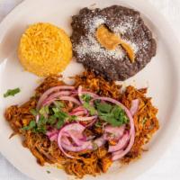 Cochinita Pibil · Tender pulled pork marinated in achiote, citrus juices and spices, baked, served on banana l...