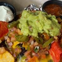 Buenos Nachos · Tri color tortilla chips topped with melted cheddar-jack, Pico de Gallo, jalapenos, sour cre...
