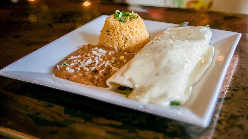 Burrito Supreme · Extra big burrito filled with your choice of tender sliced steak, or grilled chicken with onions and peppers, topped with melted cheese. Served with rice and beans.