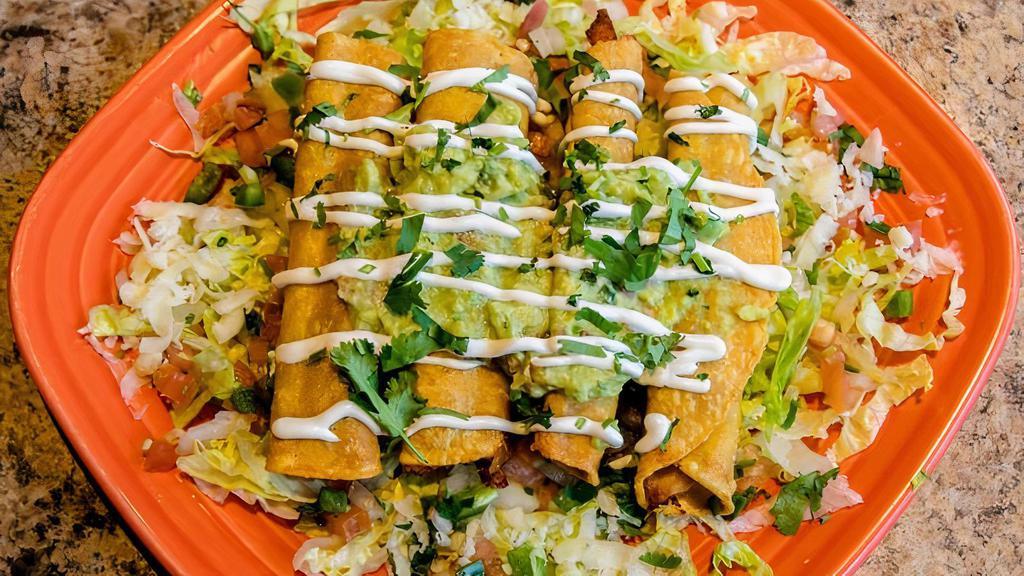 Taquitos Mexicanos · Two beef and two chicken fried corn taquitos topped with lettuce, guacamole, sour cream and pico de gallo.