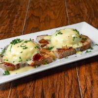 Eggs Benedict · 2 poached eggs served with bacon and hollandaise sauce over sourdough toast.