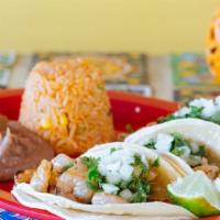Shrimp Tacos · Three marinated shrimp tacos topped with onions and cilantro. Serve with rice and beans. You...