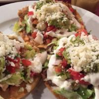 Tostadas · 3 pieces. Crispy tortilla with refried beans, lettuce, avocado, tomatoes, sour cream with ch...