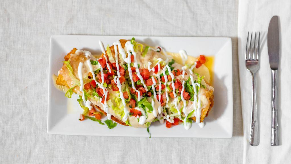 Chimichanga Supreme · Two soft or crispy flour tortillas filled with your choice of protein and topped with cheese sauce, shredded lettuce, sour cream and pico de gallo. Served with a side of rice and beans.