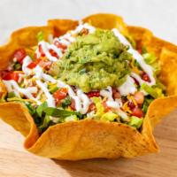 Taco Salad · A crispy flour tortilla bowl filled with lettuce, pinto beans, guacamole, sour cream, cheese...