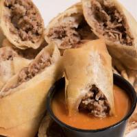 Cheesesteak Spring Rolls · Hand-rolled seasoned steak, fried onions, and American cheese in a crispy spring roll, toppe...