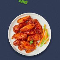 Flamin' Buffalo Wings · Fresh chicken wings breaded, fried until golden brown, and tossed in buffalo sauce. Served w...