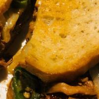 South Of The Border Grilled Cheese · Creamy melted Brie layered with chipotle BBQ pulled pork, caramelized onions and jalapenos s...