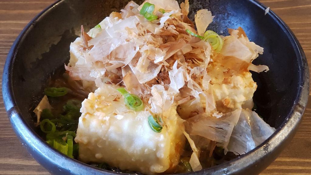 Agedashi Tofu · Lightly battered fried Japanese tofu in Tsuyu broth, grated daikon. Topped with bonito flake and scallion