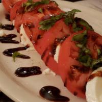 Caprese Salad · Tomatoes and fresh mozzarella served with basil, salt, pepper and finished with olive oil an...