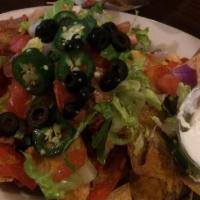 Nachos · Crispy tortilla chips topped with melted cheddar jack cheese, lettuce, tomato, onion, jalape...