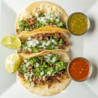 Steak Tacos · Three corn tortillas filled with grilled steak topped with cilantro, diced onions and melted...