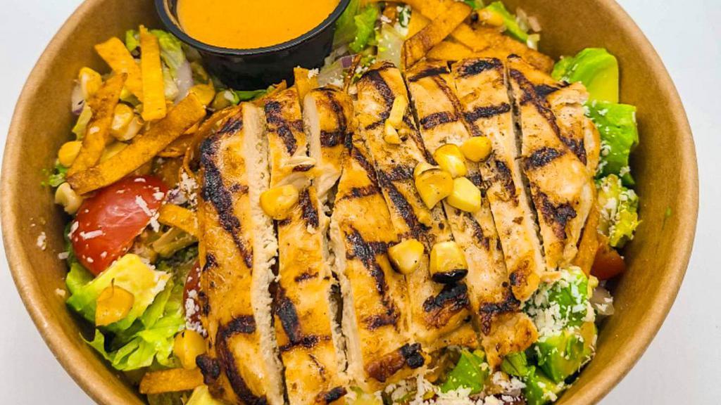 Cozumel Chopped Salad · Romaine, Roma tomatoes, grilled corn, cucumber, red onion, chili-lime tortilla strips, Cotija cheese, avocado, grilled chicken, chipotle agave vinaigrette.