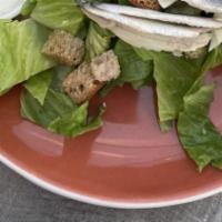 Caesar Salad · Romaine lettuce tossed in a classic dressing. Served with croutons, white anchovies and shav...