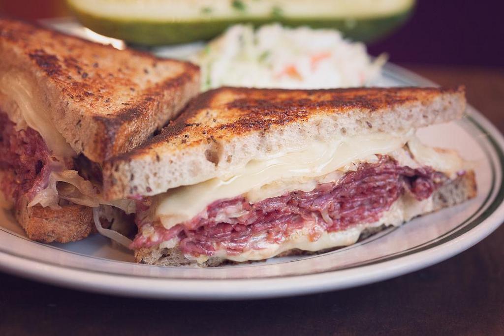 The Reubens · choice of corned beef, N.Y. style black pepper crusted pastrami or herb roasted turkey, swiss cheese, sauerkraut and russian dressing on grilled rye