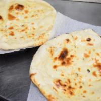 Naan · Unleavened flour bread baked in hot tandoor oven.