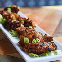 Charred Jerk Wings · Deep fried and hand-tossed in a deliciously spicy jerk sauce. Finished on the grill.