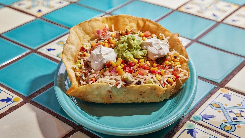 Taco Salad · This is big! Crisp tortilla bowl fi lled with shredded lettuce, cheese, corn salsa, salsa fresca, enchilada sauce and your choice of ground beef or chicken. Topped with guacamole and sour cream.