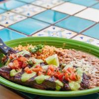 Carne Asada · 12 Ounce Grilled seasoned steak topped with hacienda sauce and salsa fresca. Served with Mex...