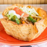 Fajita Taco Salad · A crisp flour tortilla shell filled with onions, bell peppers, and tomatoes. Served with bea...