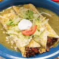 Burritos De Carnitas · Two burritos filled with carnitas, rice and beans. Topped with green sauce, lettuce, sour cr...