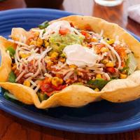 Taco Salad · This is big! Crisp tortilla bowl filled with shredded lettuce, cheese, corn salsa, salsa fre...