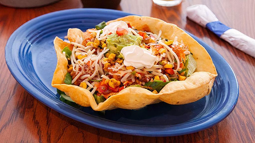 Taco Salad · This is big! Crisp tortilla bowl filled with shredded lettuce, cheese, corn salsa, salsa fresca, enchilada sauce and your choice of ground beef, chicken or pork. Topped with guacamole and sour cream.