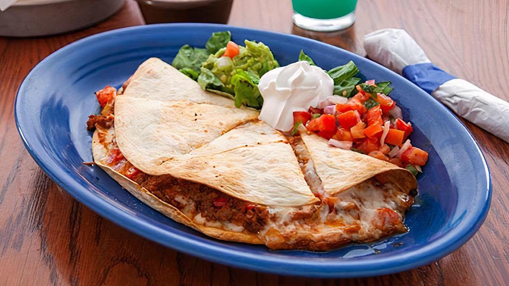 Quesadilla Extravaganza · Most popular. Seasoned chicken, ground beef, braised beef, pork carnitas, or sauteed spinach, in a flour tortilla baked with salsa fresca, mild chilies, and cheese. Served with sour cream, salsa fresca, fresh jalapenos, and guacamole.