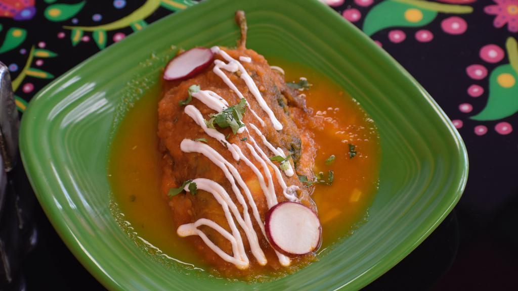 Chile Relleno · One poblano pepper egg-battered, stuffed with cheese, topped with red traditional salsa and drizzled sour cream.