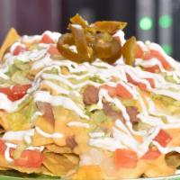 Nachos · No meat. Topped with refried beans, lettuce, tomatoes, nacho cheese, jalapeños slices and dr...